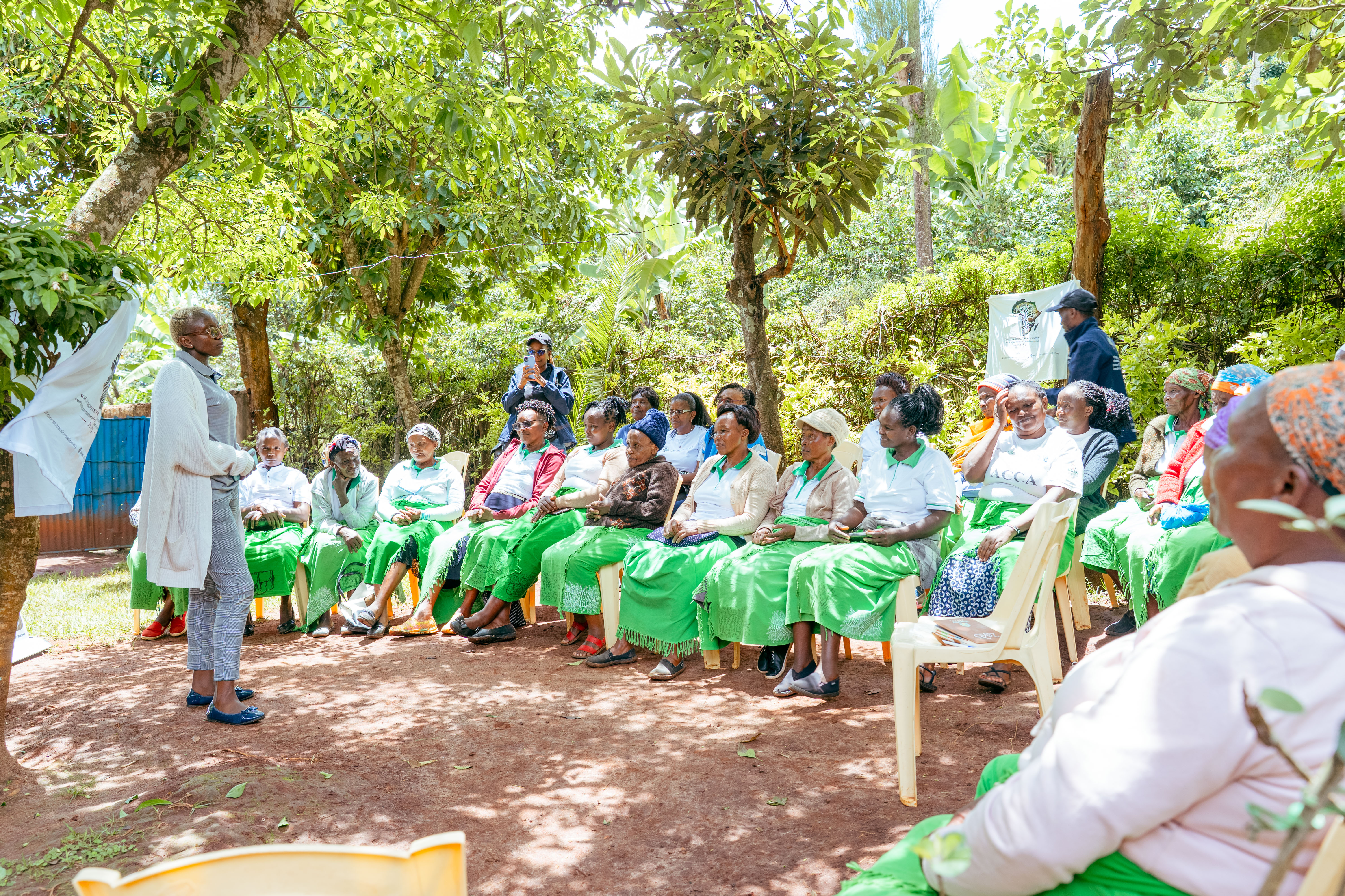 Farmer receiving seeds and tools at community distribution event in Machakos County, warm sunlit outdoor setting